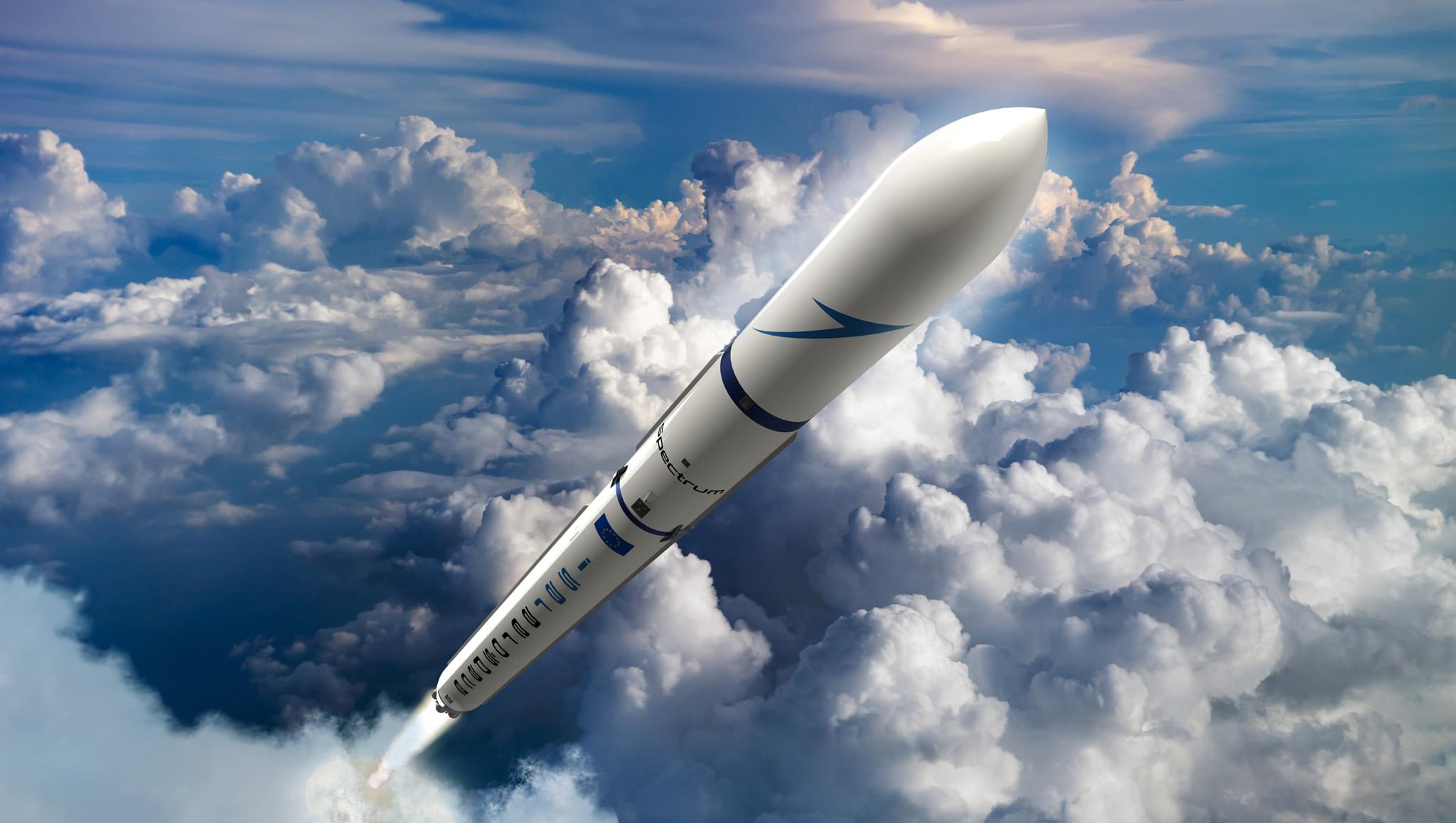 Weiße Trägerrakete startet durch Wolkendecke in den blauen Himmel.
